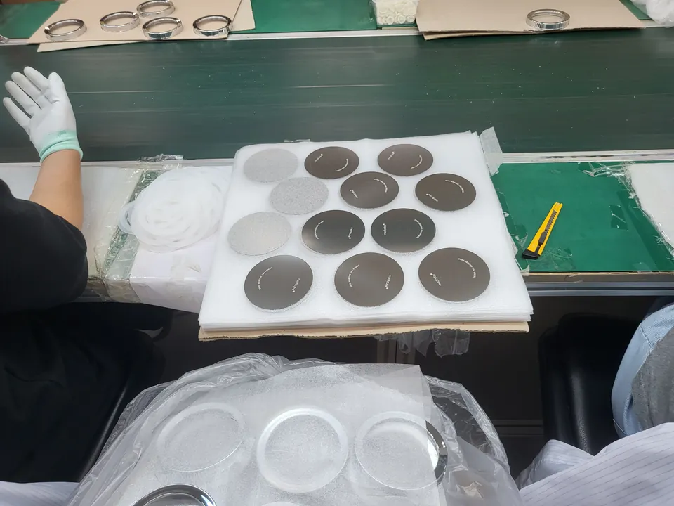 Hände mit Handschuhen montieren Filterteile in einem Werk in Korea