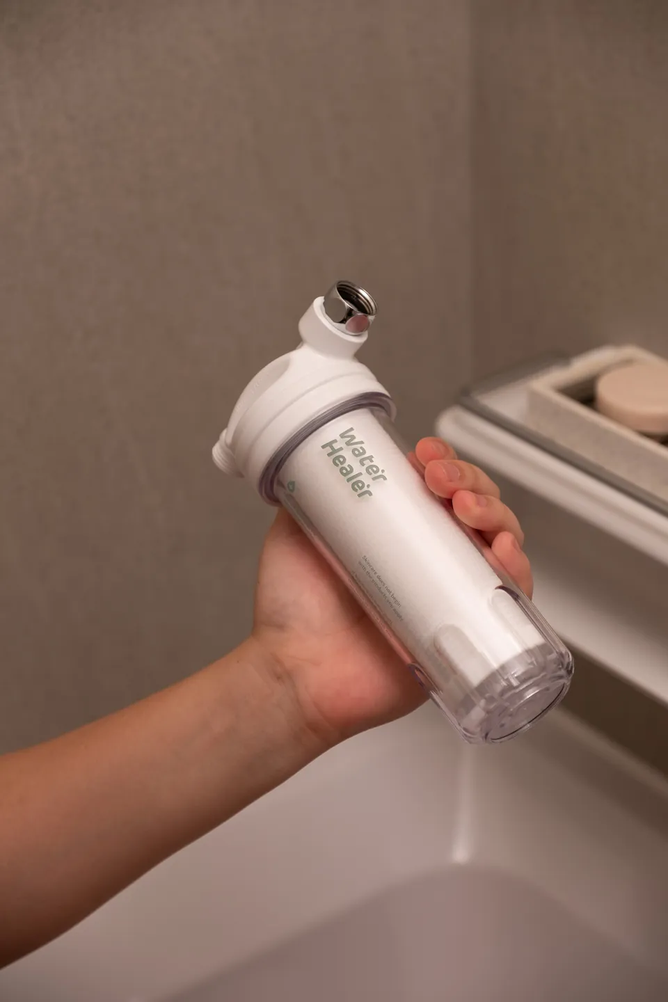 Duschfilter mit großer Kapazität in der Hand über einer Badewanne